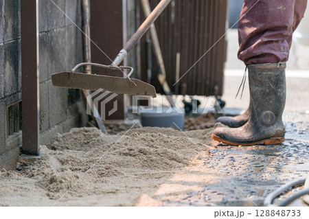 レーキで砂を均す土木作業員 レーキで砂を均す土木作業員 128848733