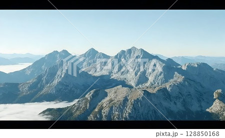 Majestic Alpine Peaks Pierced by Misty Valley 128850168