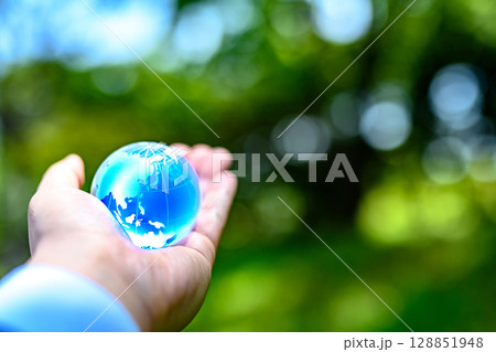 綺麗な新緑にかざす地球儀の水晶　エコロジーイメージ　青色ノーマル 128851948