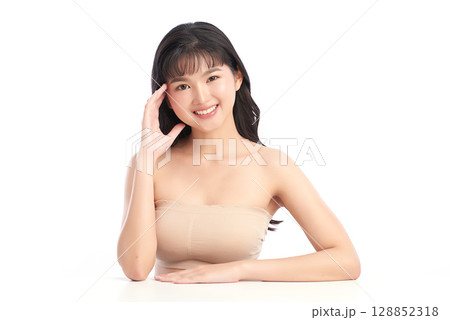 A beautiful young Asian woman with clean, fresh skin against a white background. Skincare, facial treatment, cosmetology, beauty, and spa. An elegant portrait of an Asian woman. 128852318