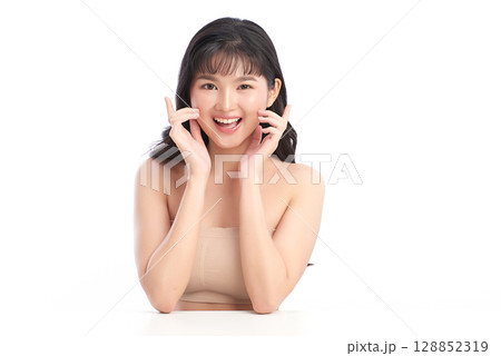 A beautiful young Asian woman with clean, fresh skin against a white background. Skincare, facial treatment, cosmetology, beauty, and spa. An elegant portrait of an Asian woman. 128852319