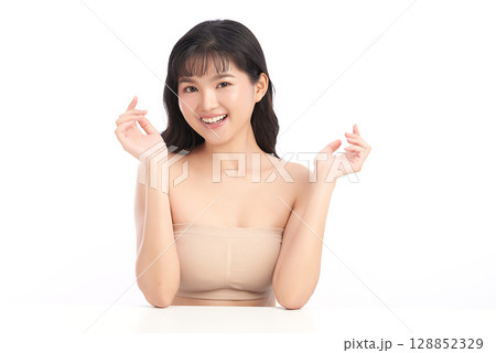 A beautiful young Asian woman with clean, fresh skin against a white background. Skincare, facial treatment, cosmetology, beauty, and spa. An elegant portrait of an Asian woman. A beautiful young Asian woman with clean, fresh skin against a white background. Skincare, facial treatment, cosmetology, beauty, and spa. An elegant portrait of an Asian woman. 128852329