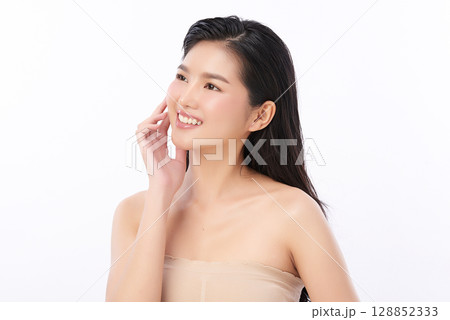 A beautiful young Asian woman with clean, fresh skin against a white background. Skincare, facial treatment, cosmetology, beauty, and spa. An elegant portrait of an Asian woman. 128852333