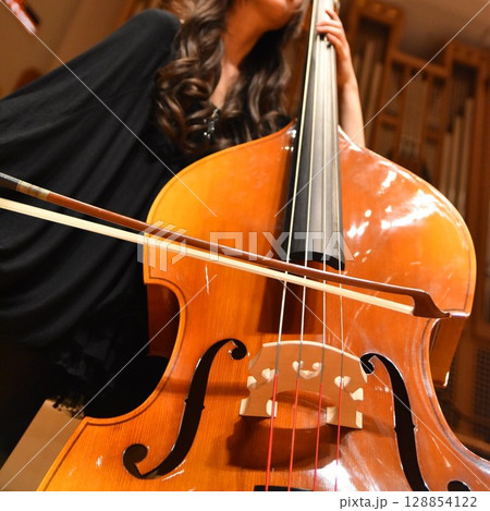 発表会でコントラバスを弾く女性奏者 発表会でコントラバスを弾く女性奏者 128854122