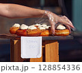Hand Picking Homemade Pastry with Cream Filling at Open-Air Market 128854336