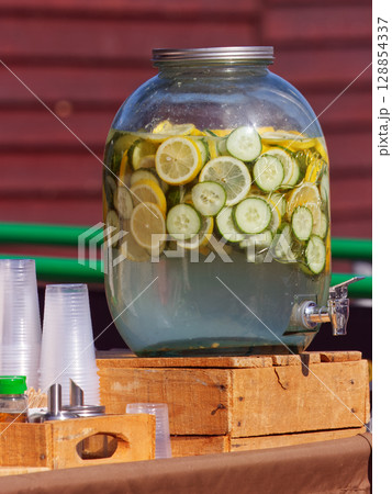 Fresh Citrus and Cucumber Infused Water in a Clear Drink Dispenser Fresh Citrus and Cucumber Infused Water in a Clear Drink Dispenser 128854337