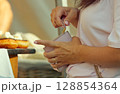Woman Handling Wallet Near Pastry Display in a Market Environment 128854364