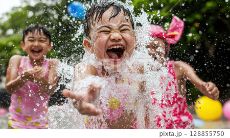 Joyful children splashing water in pool, enjoying sunny day together 128855750