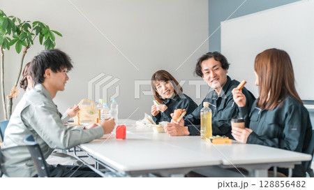 休憩室でランチ,お弁当を食べる作業服姿のビジネスマン男女 休憩室でランチ,お弁当を食べる作業服姿のビジネスマン男女 128856482