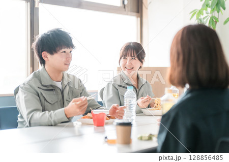 休憩室でランチ,お弁当を食べる作業服姿のビジネスマン男女 休憩室でランチ,お弁当を食べる作業服姿のビジネスマン男女 128856485