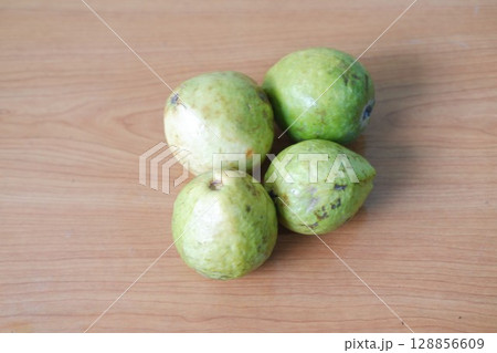 Four Ripe Guavas on Rustic Surface Four Ripe Guavas on Rustic Surface 128856609