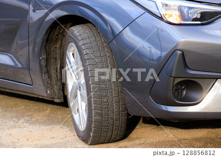 スタッドレスタイヤに履き替えて安全に走行する自動車 128856812
