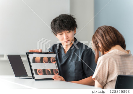 内視鏡検査で検査画像を見ながら女性患者と話をする男性医師 内視鏡検査で検査画像を見ながら女性患者と話をする男性医師 128856898