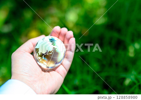 綺麗な新緑に上からかざす地球儀の水晶　エコロジーイメージ　虹色 128858980