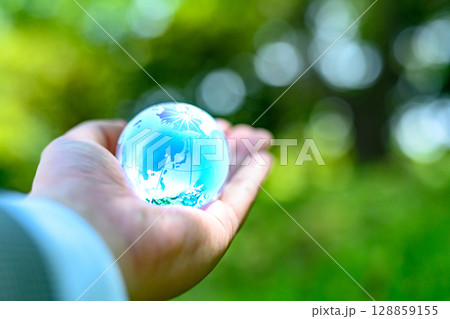 綺麗な新緑にかざす地球儀の水晶　エコロジーイメージ　水色明るめ 128859155