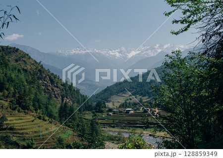Terraced farming in Nepal. Village on a terraced hill during Annapurna Circuit Trek in Himalayas, Annapurna Conservation Area, Nepal. Rise fields. Agricultural concept Terraced farming in Nepal. Village on a terraced hill during Annapurna Circuit Trek in Himalayas, Annapurna Conservation Area, Nepal. Rise fields. Agricultural concept 128859349