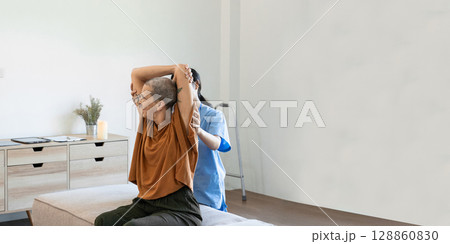 Healthcare Professional Assisting Senior During Home Visit for Physical Therapy and Rehabilitation 128860830