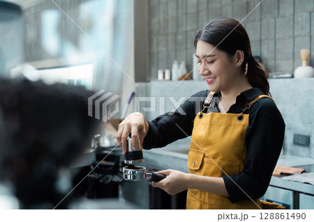Barista in Yellow Apron Preparing Espresso in Modern Coffee Shop Barista in Yellow Apron Preparing Espresso in Modern Coffee Shop 128861490