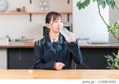 ペットボトルの水,スポーツドリンク,経口補水液,清涼飲料水を飲む中学生,高校生,小学生,生徒の女の子 128861682