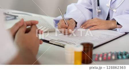 Medical Documentation. Doctor writing patient information during consultation. 128862363