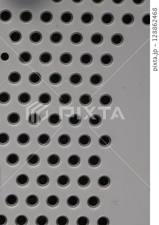 dirty plastic with lots of round holes, plastic surface with holes for ventilation, close up dirty plastic with lots of round holes, plastic surface with holes for ventilation, close up 128862468