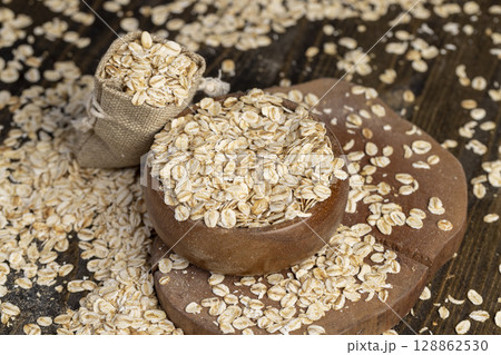 bag with oatmeal flakes, dry cereal flakes from oats, flattened, steamed and dried, close up 128862530