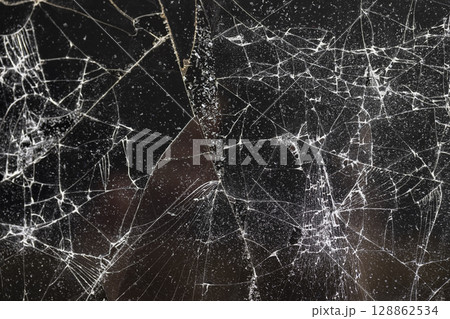 broken with a lot of damage and pieces of glass on a black background, thin glass broken into pieces 128862534