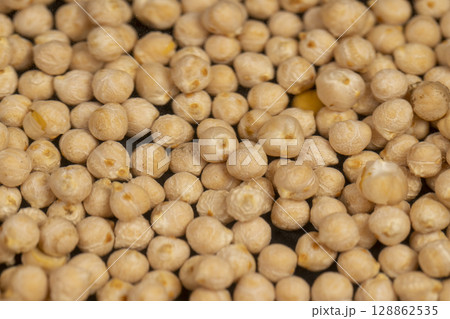 yellow chickpeas floating in the water, poured into the water a large number of chickpeas, closeup 128862535