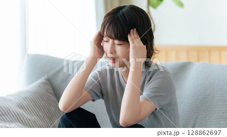 頭を押さえて悩む女性 頭を押さえて悩む女性 128862697