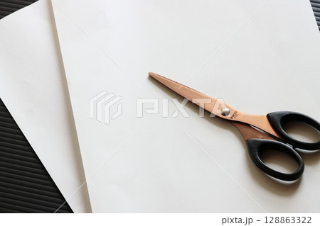 テーブルの上に置かれたハサミと紙 テーブルの上に置かれたハサミと紙 128863322