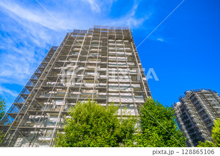 日本の横浜都市景観　夏空が広がる…マンションの補修や点検等、足場や防護ネット、衛星アンテナが… 128865106