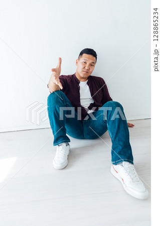 Asian man sitting on the floor and his hand 128865234