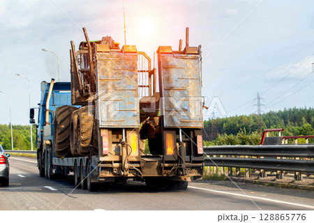 Transportation of large construction equipment on a trawl trailer. Trawl trailer service concept, industry. Copy space for text, construction engineering, sunset 128865776