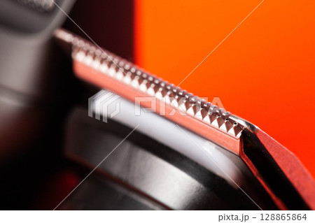 beard trimmer on a red background, close-up. Hair and beard care, close-up beard trimmer on a red background, close-up. Hair and beard care, close-up 128865864