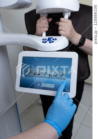 Advanced Dental Imaging Technology in Action: A Patient Undergoing 3D Scan with User-Friendly Tablet Interface for Comprehensive Diagnostic Assessment Advanced Dental Imaging Technology in Action: A Patient Undergoing 3D Scan with User-Friendly Tablet Interface for Comprehensive Diagnostic Assessment 128866100