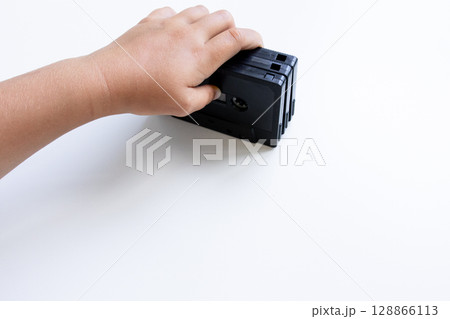 Child hand holding vintage vhs tape on white background 128866113