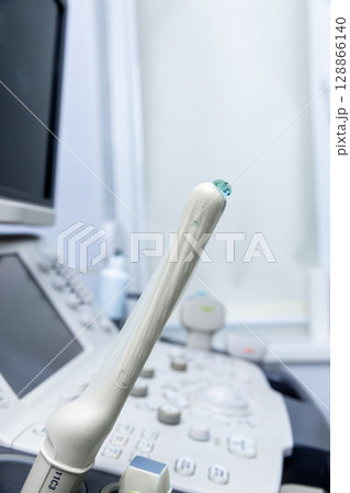 Close-Up of an Ultrasound Probe on a Medical Console Amidst a Clean and Modern Medical Environment with Equipment Ready for Efficient Patient Care and Diagnostics Close-Up of an Ultrasound Probe on a Medical Console Amidst a Clean and Modern Medical Environment with Equipment Ready for Efficient Patient Care and Diagnostics 128866140