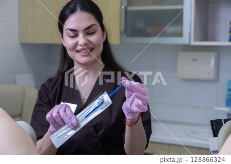 A Friendly Medical Professional Preparing Tools for a Procedure in a Modern Clinic Environment with a Bright Smile and Professional Attire 128866324