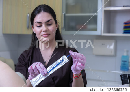 Professional Female Clinician in Medical Setting Preparing Equipment for a Procedure with Careful Attention and Safety Measures in a Clean and Sterile Environment 128866326