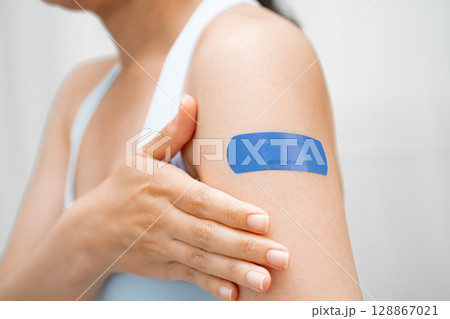 HPV, Human papillomavirus, Asian young woman receiving vaccine with blue bandage. 128867021