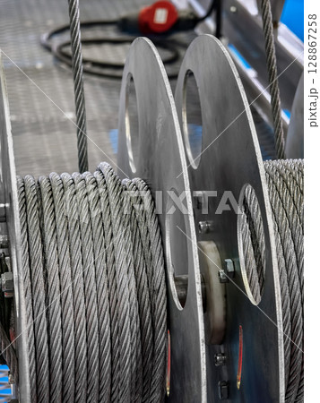 Heavy-duty steel cables on spools in an industrial setting at a construction site 128867258