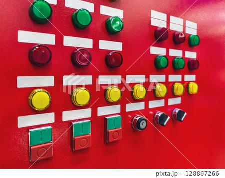 Control panel with colorful buttons in a modern industrial setting for machinery operation Control panel with colorful buttons in a modern industrial setting for machinery operation 128867266