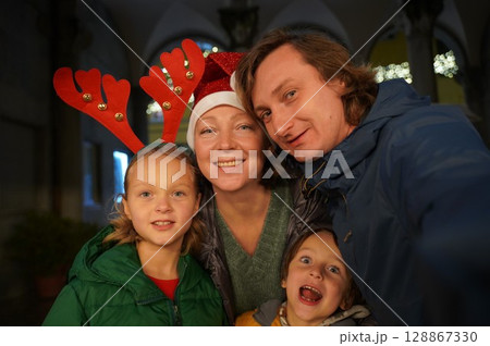 Festive Family Selfie with Santa Hats and Reindeer Ears Festive Family Selfie with Santa Hats and Reindeer Ears 128867330