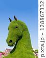Dubai Miracle Garden, UAE  21 November 2025. Giant topiary sculpture of a horse head made from green plants and foliage, set against a vibrant floral landscape 128867332