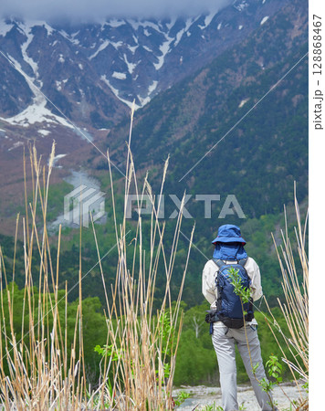 夏の観光名所上高地の穂高連峰の風景を楽しむ女性観光客の姿 夏の観光名所上高地の穂高連峰の風景を楽しむ女性観光客の姿 128868467