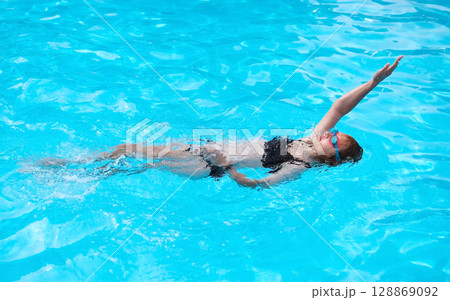 Young Girl Swims Backstroke In Outdoor Pool 128869092