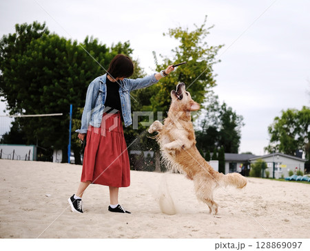 Girl Playing And Training Wet Golden Retriever The River, Happy Pet Running Outdoors 128869097