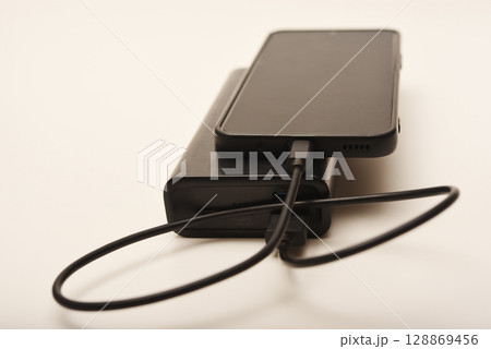 Charging a mobile phone from a powerbank. Charging the gadget. 128869456