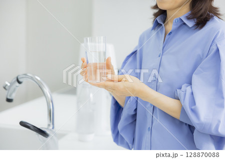 キッチンで水を飲む女性  128870088