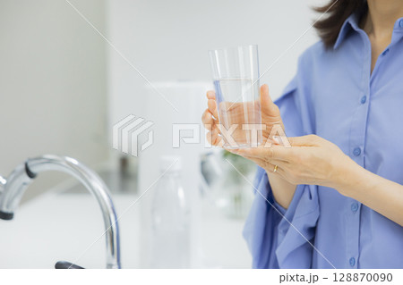 キッチンで水を飲む女性  128870090